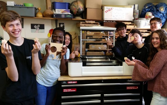 middle school students with laser cutter