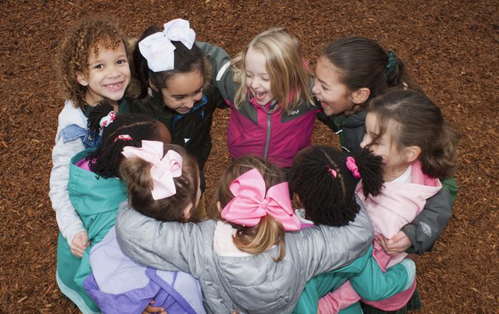 lower school students form a circle on the playground