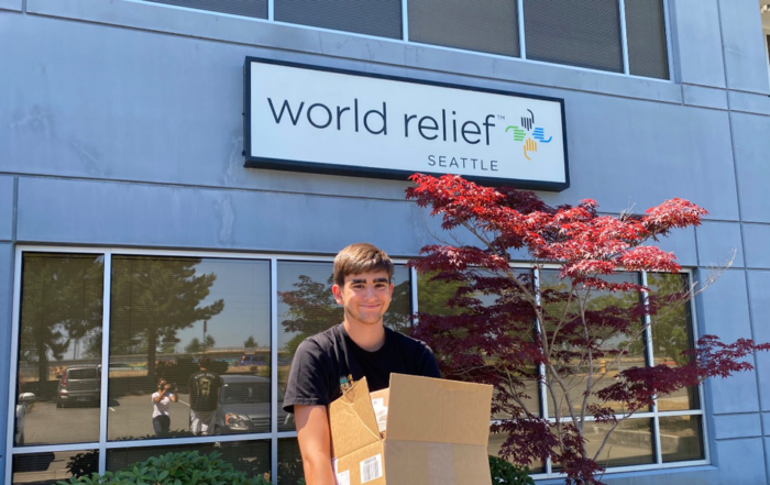 Ian P holding boxes in front of World Relief (Seattle).